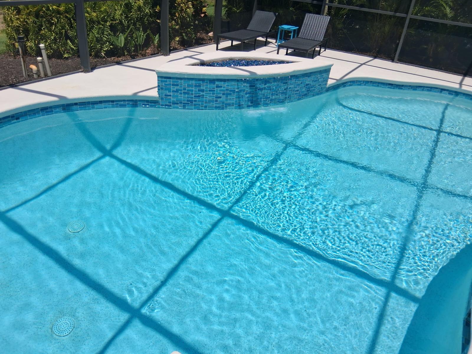 Piscina residencial limpia con iluminación y spa en Naples FL